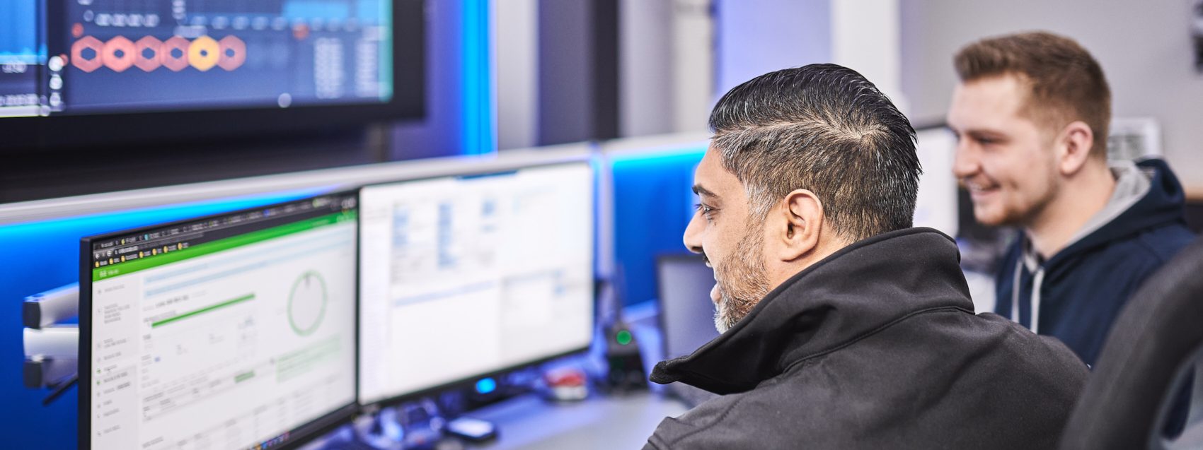 Mitarbeitende der Axians, einem der größten Citrix Partner Deutschlands, arbeiten gemeinsam an zwei Bildschirmen